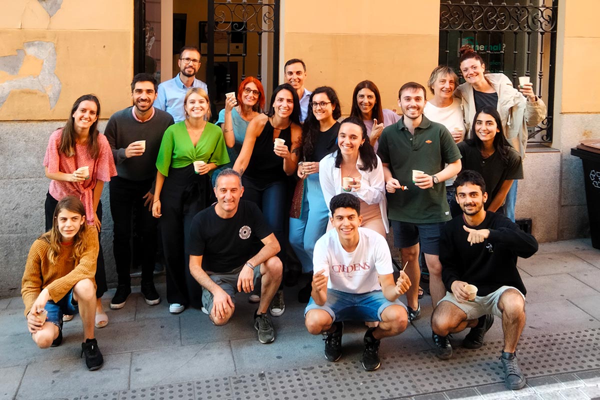 grupo de personas jovenes que sonrien mientras estan delante de un edificio amarillo en el barrio de Malasaña Madrid